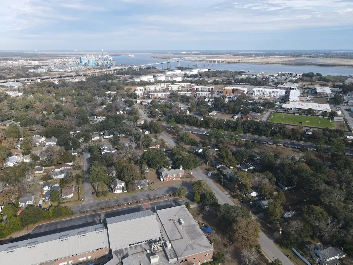 A scenic view of the river, bridge, city skyline, and residential neighborhoods. The waterfront is inviting, perfect for walking, biking, or simply enjoying the view. The setting is peaceful, yet vibrant, embodying the natural beauty and outdoor lifestyle of the area.