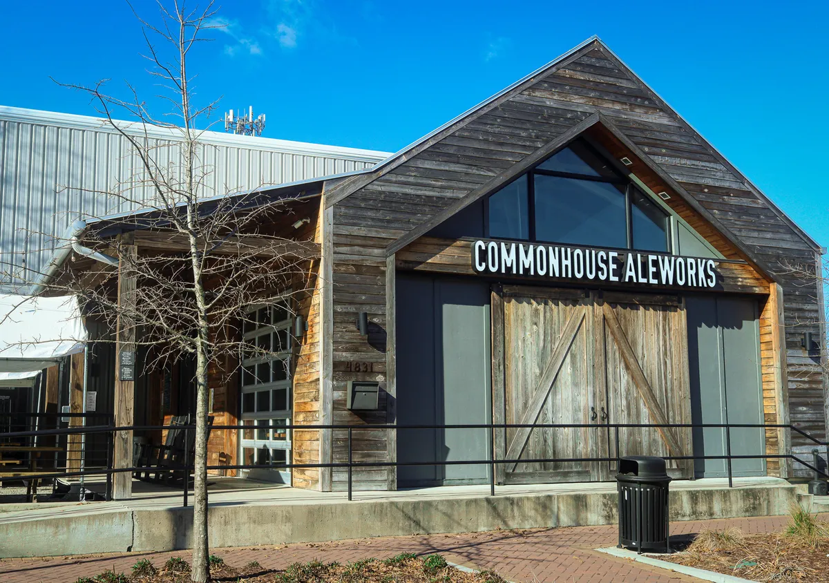 The welcoming facade of Commonhouse Aleworks, featuring prominent wooden doors, large windows, and striking signage. The exterior hints at a convivial atmosphere inside, inviting gatherings, tasting events, and participation in community happenings.