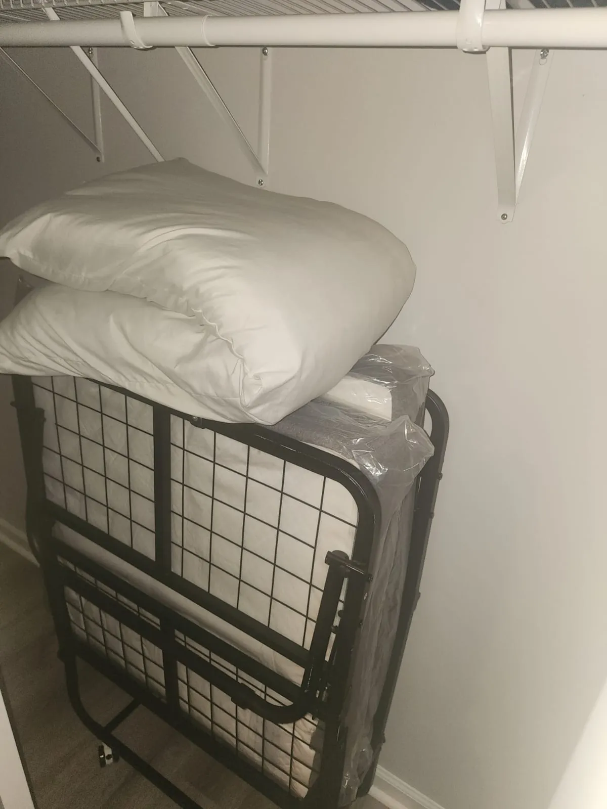 A compact interior with a folding bed and pillows, emphasizing versatility and space-saving solutions. The bed can be tucked away, making the room flexible for both guests and storage.